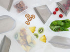 Zip Topブランドのプラチナシリコーン製食品保存容器セット。異なるサイズの容器に果物や野菜が入っており、蓋付きトレイが重ねられたキッチン用品の写真