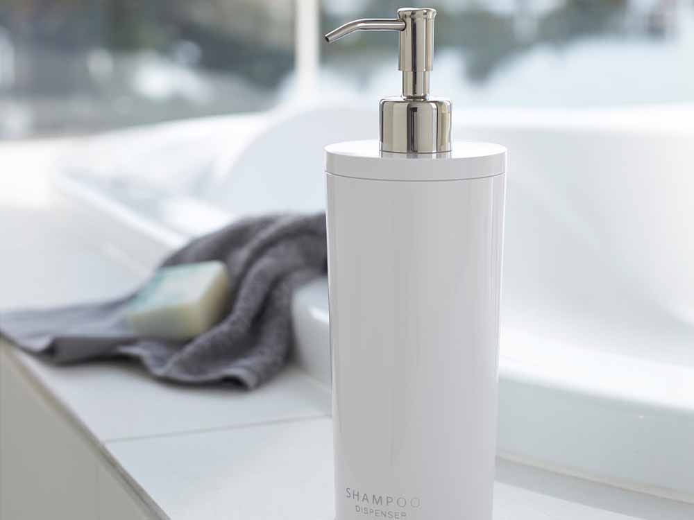YAMAZAKI/tosca製【tower/タワー】ツーウェイディスペンサー ラウンド、500ml容量のABS樹脂ボトルとステンレスポンプを備えたソープディスペンサーがバスルームの洗面台に設置されている