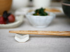 sarasa design×イブキクラフトの白色陶器製箸置きと他の食器が並んだテーブル上の写真