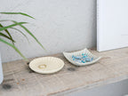 俊峰陶苑の花あかり角小皿。手作りの自然な風合いを持つ80～85㎜角の陶器製小皿で、各々異なる表情を楽しめます