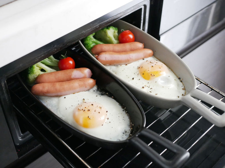 IBUKICRAFT/イブキクラフトの耐熱陶器製魚焼きグリルプレートと新鮮な野菜がキッチンで調理されている様子