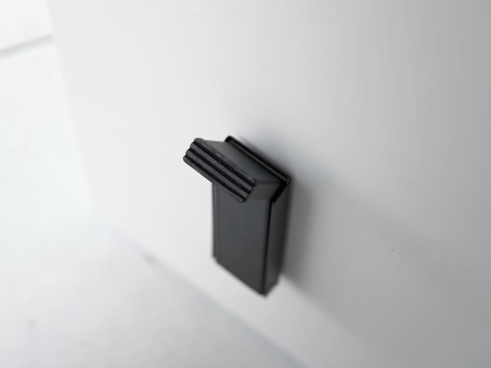 スチール製のマグネット折りたたみドアストッパー「tower」の正面画像。粉体塗装された本体にシリコーン製の滑り止めが付いており、コンパクトに折りたためるデザインです。